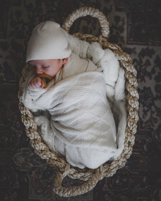 A newborn sleeping in a basket