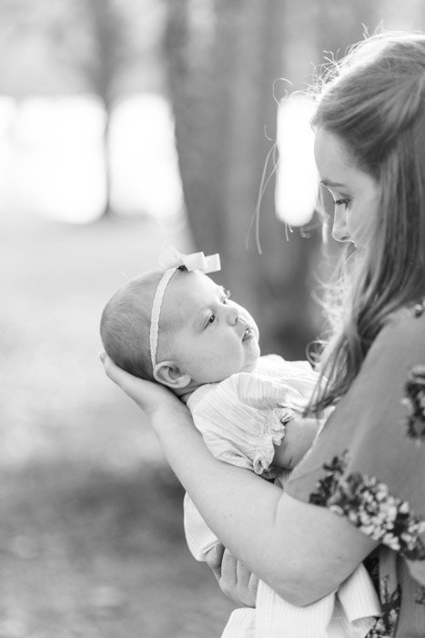 Black and white newborn photography of a woman holding a baby