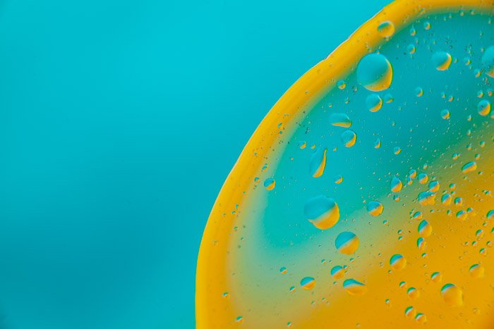 Aqua blue background with a circle of yellow liquid on the right side 