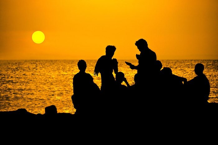 Silhouette of a group of people by the sea
