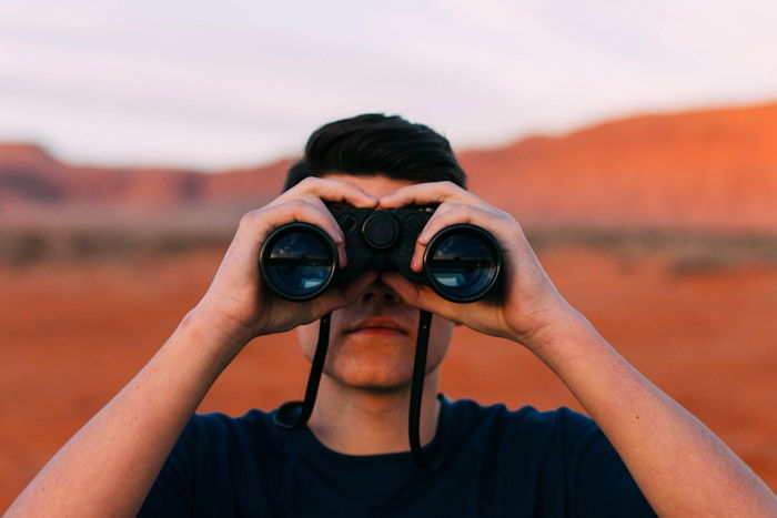 A photographer with binoculars