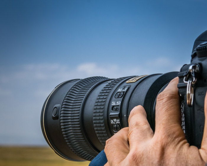 A photographer using a telephoto lens for stunning wildlife photography shots