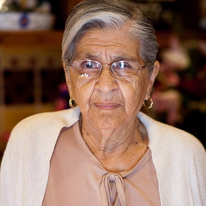 An elderly wedding guest with glasses looks at the camera. Amateur wedding photographer
