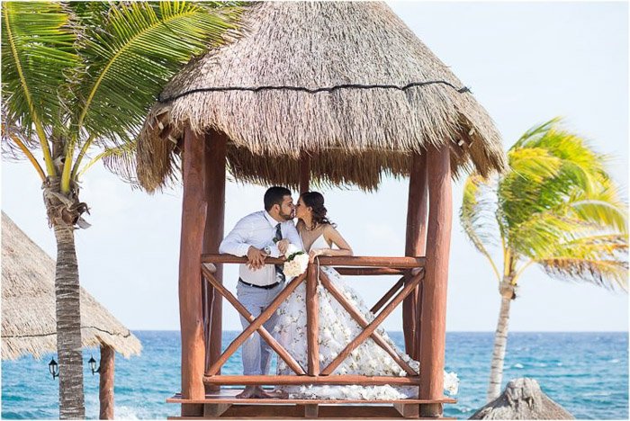  a newlywed couple kissing in a hut on the beach on a clear day. Amateur wedding photography.