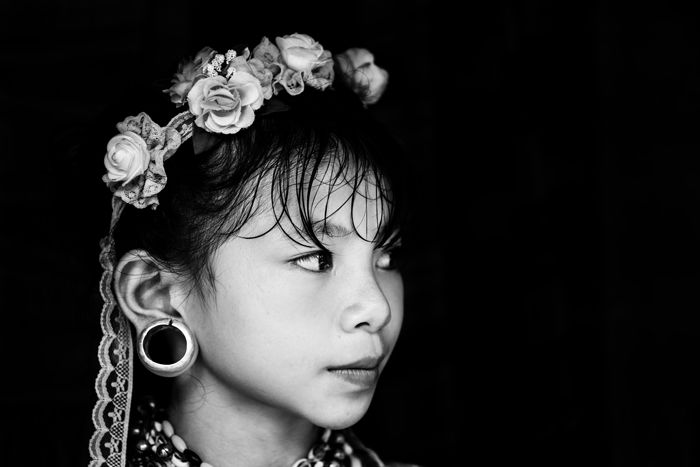 black and white travel portrait of a young girl with white flowers in her hair and traditional jewellery