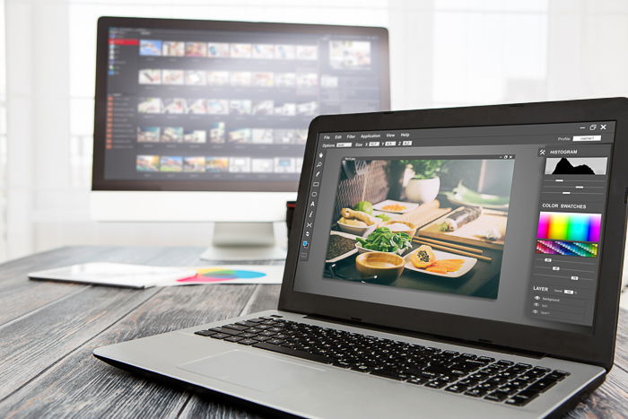 A laptop and PC on a wooden table