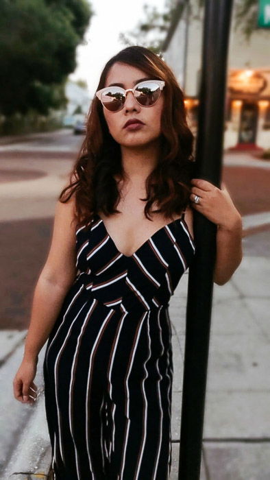 Portrait of a girl in a black and white striped outfit standing next to a pole in an urban street setting - Smartphone fashion photography shoot