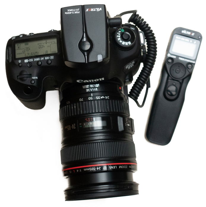 Canon camera with a separate intervalometer accessory on white background.