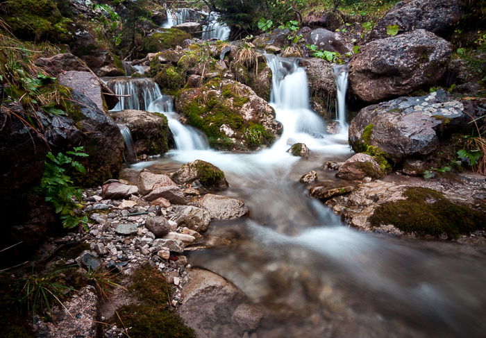 A rockpool at the bottom of a waterfall.