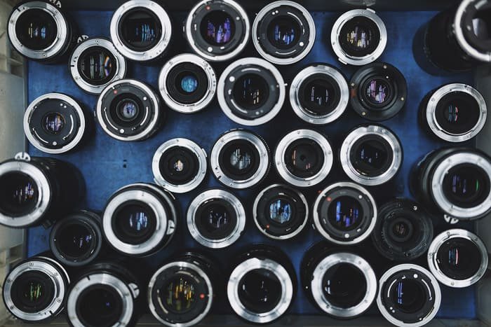 Overhead Photo of a range of wedding photography lenses on blue background