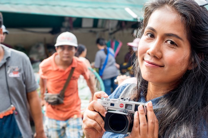 A girl holding a camera in Chiang Mai, Thailand, documentary photography