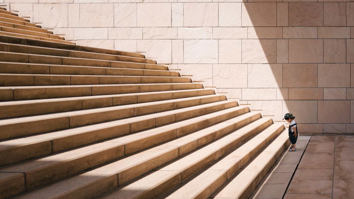 Photo of a small child standing at the end of large stone steps