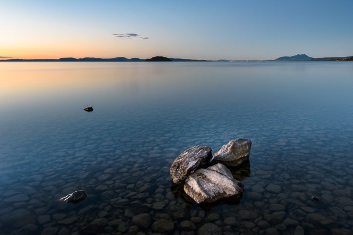 日落时平静的海面上的一群岩石。风景摄影构图