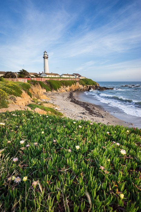 A bright landcape photo of a coastline with lighthouse in the background. Landscape photography composition