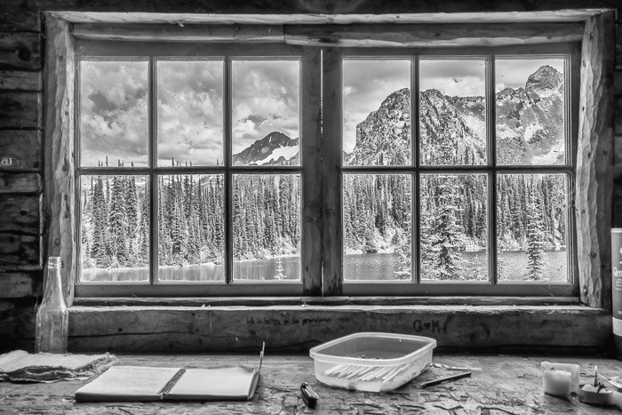 An icy landscape photographed through a cabin window. Natural framing for landscape photography composition