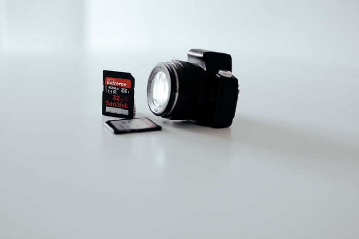 Image of a camera and memory card on a white background.