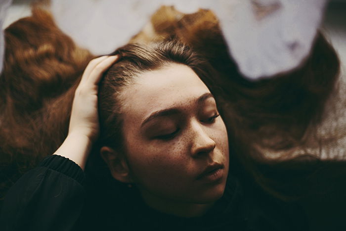 moody portrait of a girl with long hair, natural light portrait photography