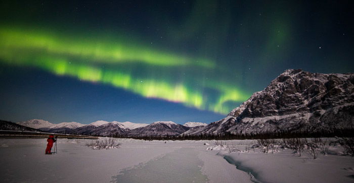 A mountain scene with a photographer during an aurora borealis photography workshop