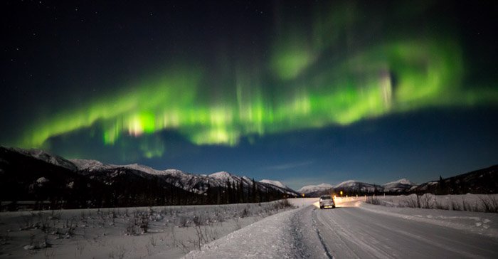 Stunning view of the northern lights over an icy road