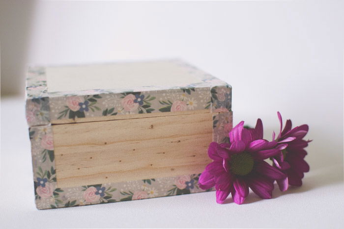 A close-up of a wooden box beside purple flowers as an idea of what to do with photos