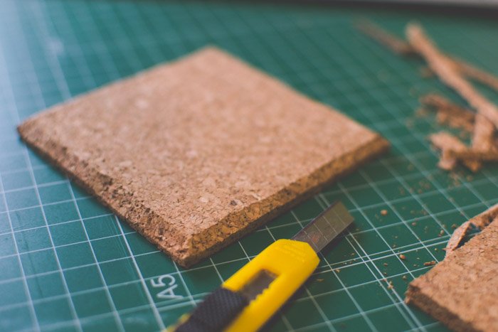 A close up of a coaster being trimmed on a cutting mat. Creative photography ideas.