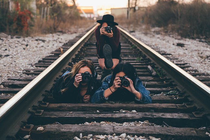 Photoof three girls on train tracks holding cameras. Self portrait ideas