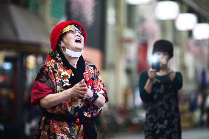 Travel photography of a woman being photographed by another woman with smartphone.