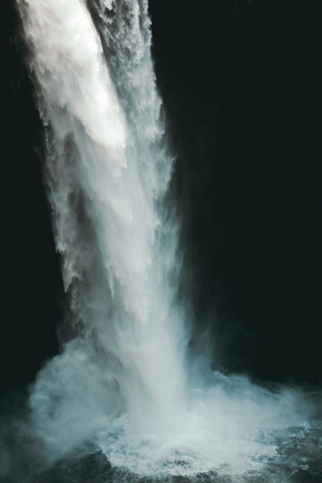 A flowing waterfall hitting a pool of water