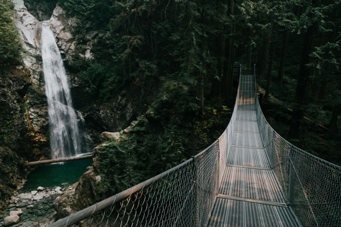 A waterfall in the background of an image of a bridge