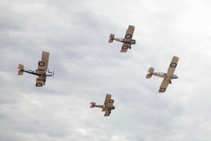 An airshow photography shot of 4 airplanes flying on an overcast day