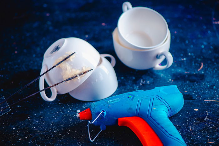 Overhead shot of coffee cups and gluegun on starry blue background for creative Coffee Splash photography project