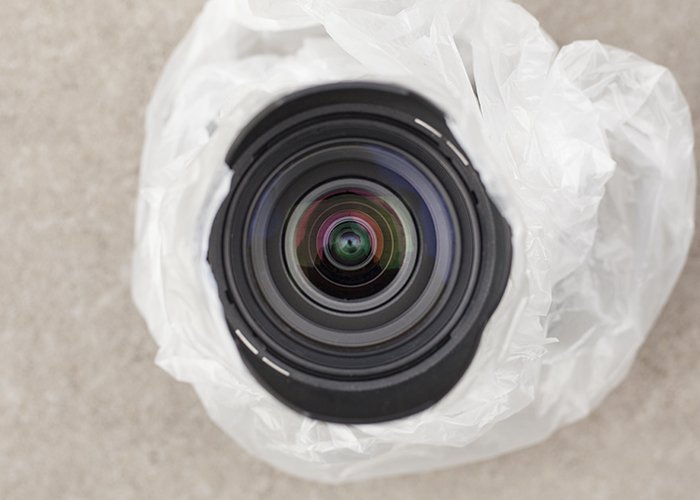 Overhead photo of a DSLR lens protected in plastic for rain photography