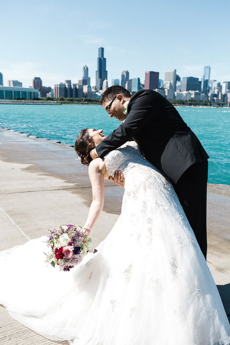 Fun wedding photo of a couple embracing in front of a river