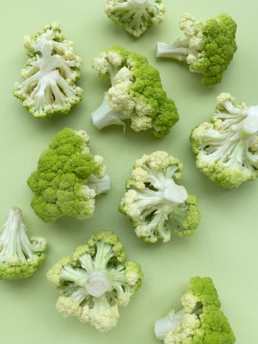 Interesting overhead shot of pale green broccoli on pale green background