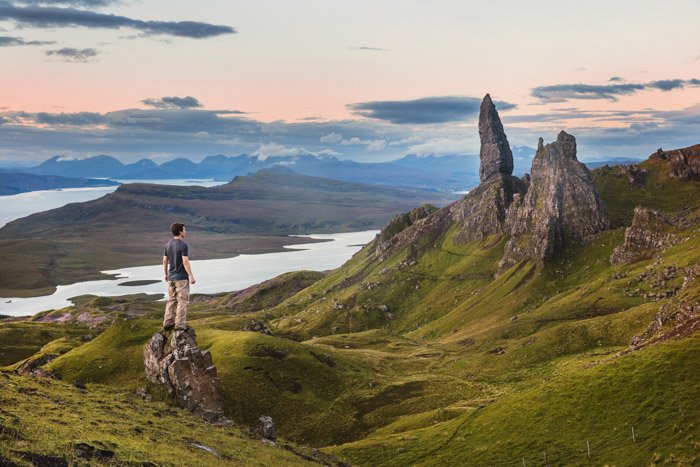 一个人站在岩石上，身后是壮丽的风景