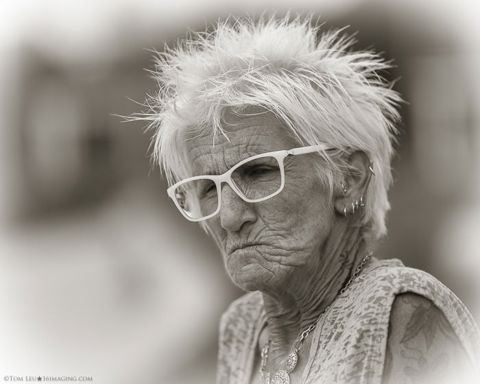 A black and white portrait of an elderly woman in glasses - freelance photography tips