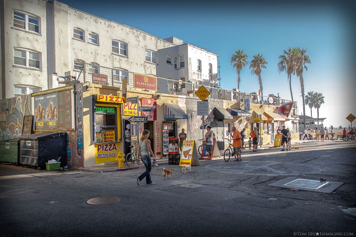 Street photography of a girl walking down a road on a sunny day - V