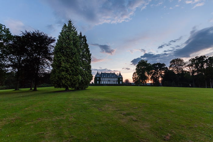 A balanced and natural countryside landscape with a castle in the background. HDR photography mistakes.