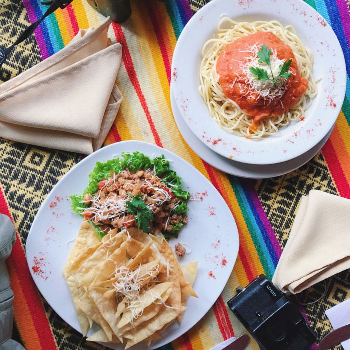 Overhead shot of two plates with food on a brightly cloured tablecloth. Instagram tips for photography beginners.