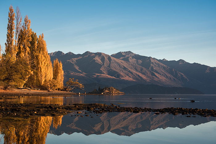 A serene landscape image of mountains and water