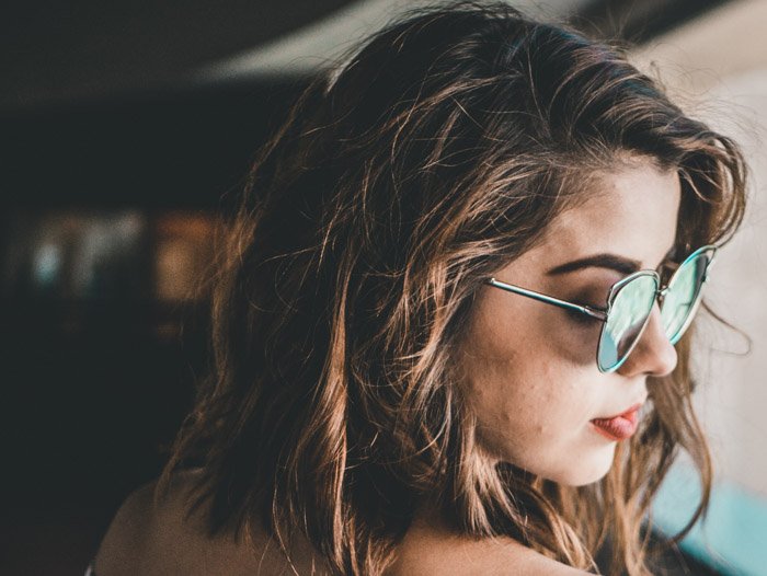 A close up portrait of a girl in sunglasses using lead room photography