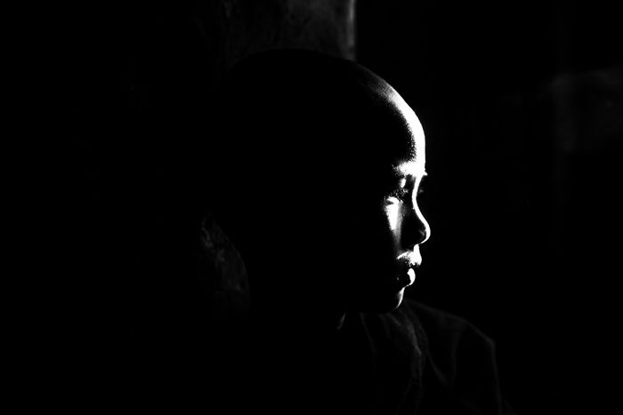 A low key monochrome photography portrait of a young boy