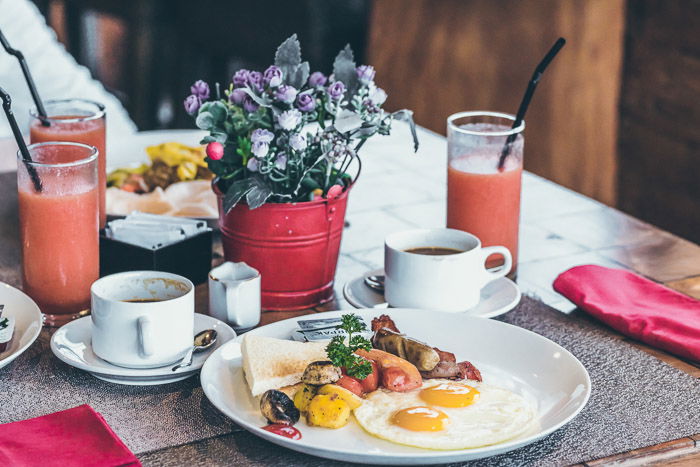 Pretty food photography of a lunch setup with plate of food, coffee cups and glasses of juice, shot with a macro lens for still life photography