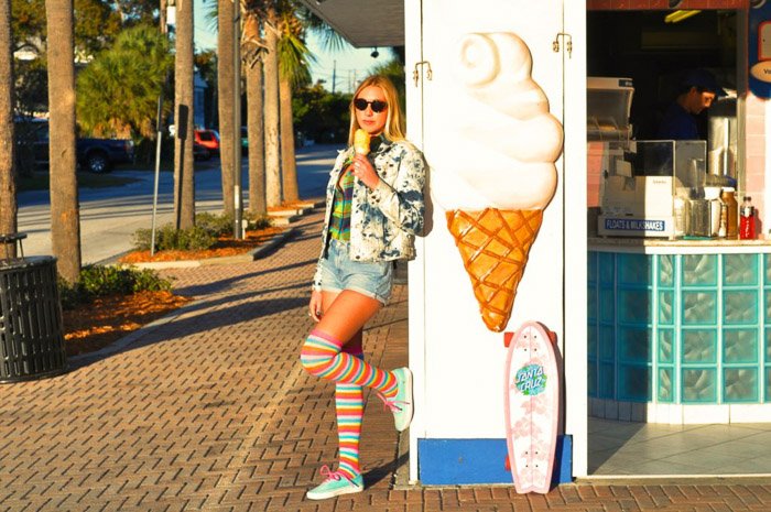 A photography model poses with an ice-cream outside a cafe