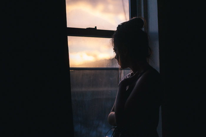 A natural light photography portrait of a girl by the window in Bushwick, Brooklyn