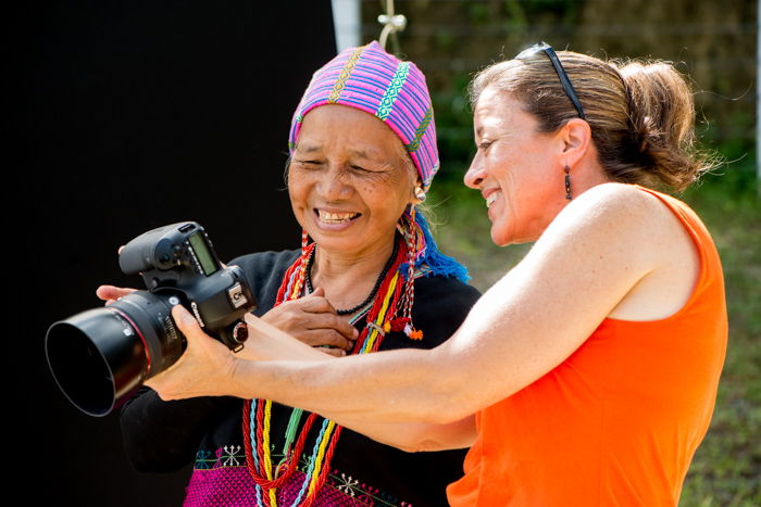 A participant in an outdoor portrait photography studio workshop showing a Karen woman her portrait
