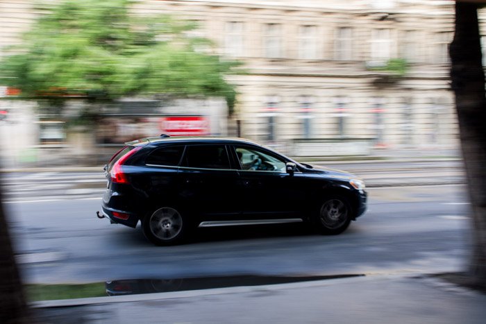 A blurry shot of a black car driving on the street