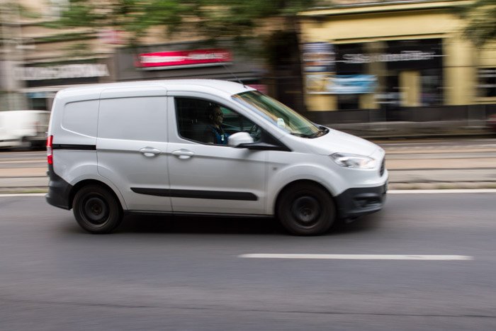 A blurry shot of a white van driving on the street