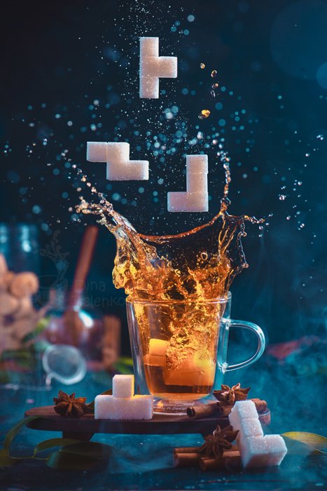 Splash of tea in a double wall glass with sugar Tetris pieces. 8-bit video game in real life concept with copy space. Creative action food photography. Still life photography ideas