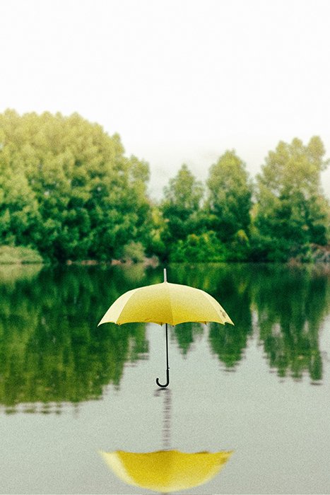 Saffu photo of a yellow umbrella floating above a lake - surreal photography